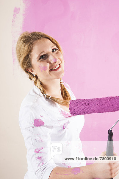 Frau  Wand  streichen  streicht  streichend  anstreichen  anstreichend  pink  jung  schießen  Studioaufnahme