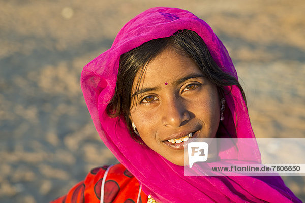 Lächelnde junge Frau mit Kopftuch und einem Bindi auf der Stirn  Porträt