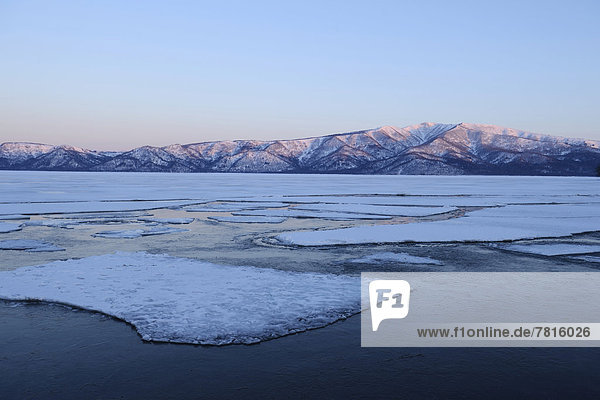 Morgenstimmung am zugefrorenen See Kussharo Lake mit Eisschollen im Vordergrund