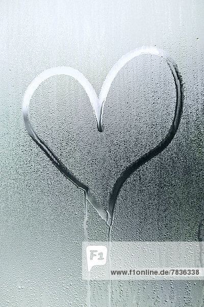 Eine Herzform  die in der Kondensation eines Fensters gezeichnet ist.