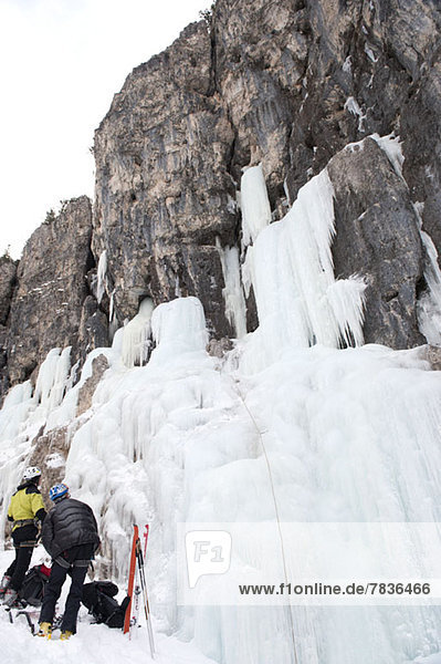 Two skiers prepare for ice climb at Lagazuoi  South Tyrol  Italy
