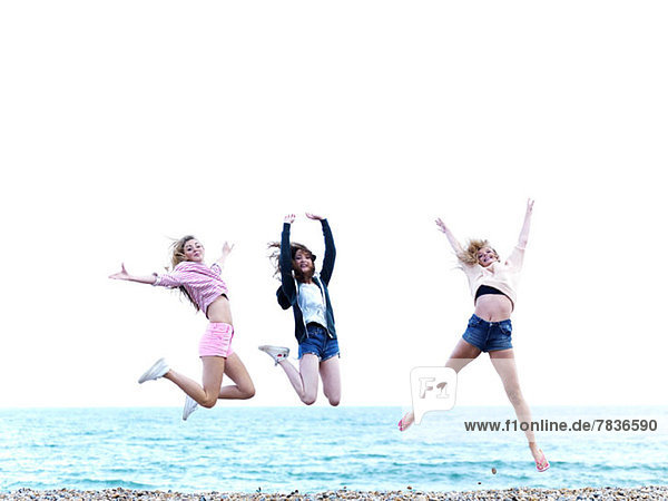 Three friends jumping in excitement on the beach