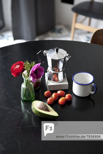 Ein Tisch mit Espressomaschine  Kaffeetasse und Zutaten für das Frühstück