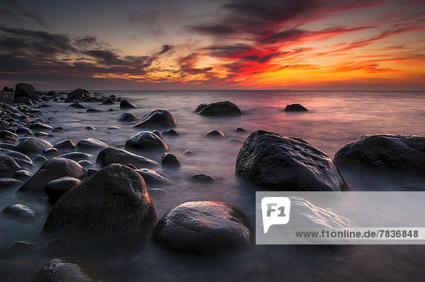 Steine am Strand bei Sonnenuntergang am Meer