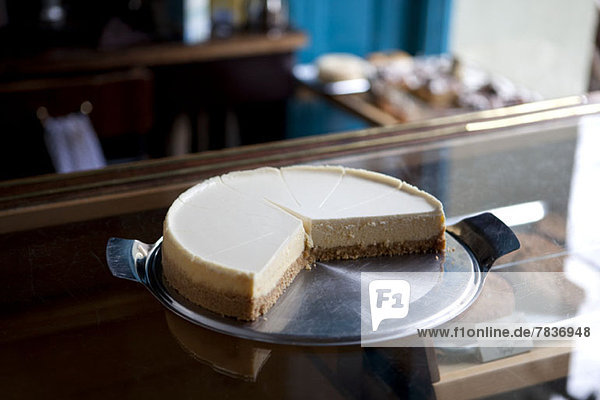 Ein in Scheiben geschnittener Käsekuchen auf einer Vitrine in einem Coffee-Shop