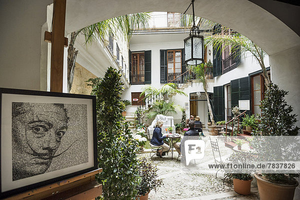Courtyard with a café  portrait of Salvador Dali at front  Dali Museum