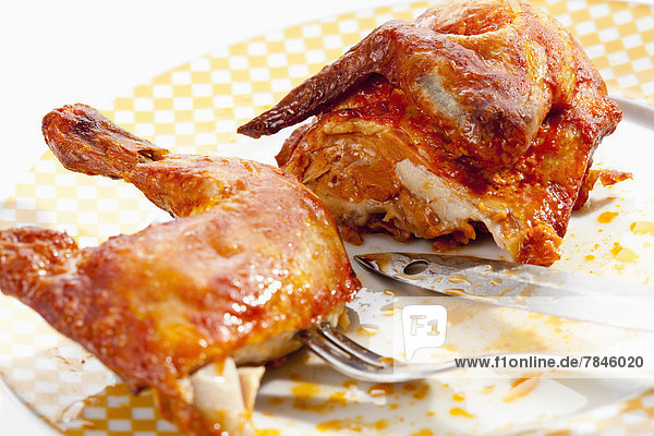 Plate of half roasted chicken close up