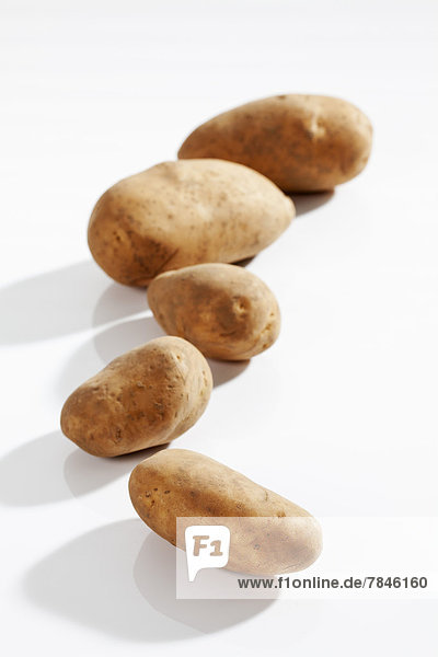 Raw potatoes on white background  close up