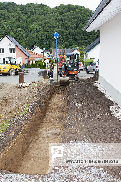 Europe  Germany  Rhineland Palatinate  Men working with excavator during house building