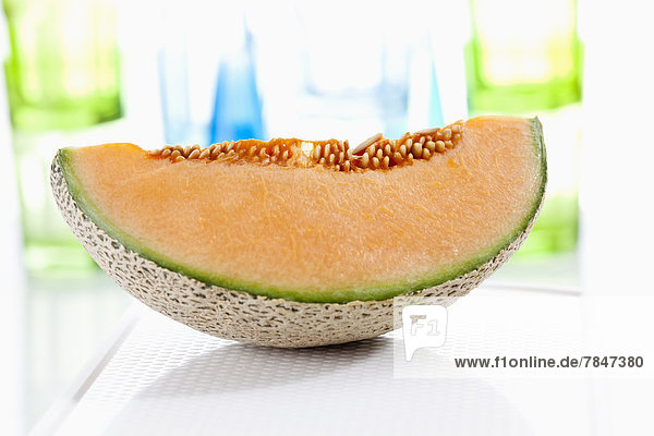Slice of cantaloupe melon on chopping board  close up