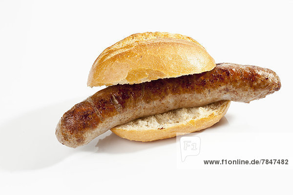 Bread roll with grilling sausage on white background  close up
