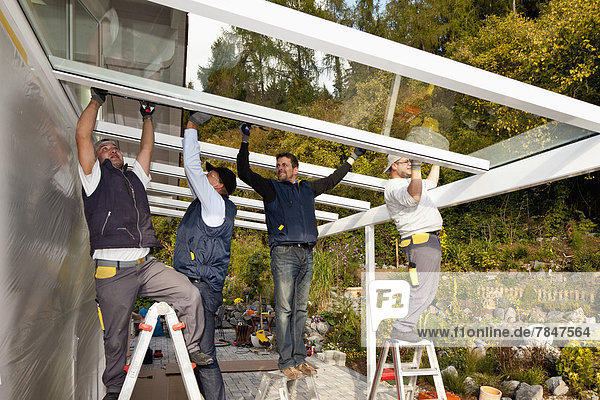 Germany  Rhineland Palatinate  Men assembling glass canopy