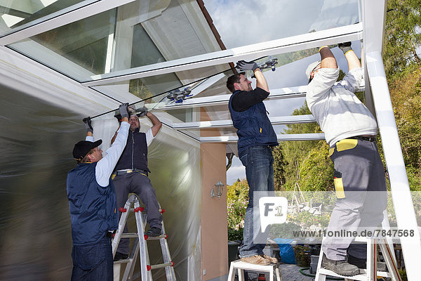 Germany  Rhineland Palatinate  Men assembling glass canopy