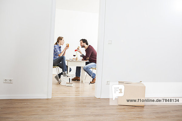 Couple eating pizza in new house