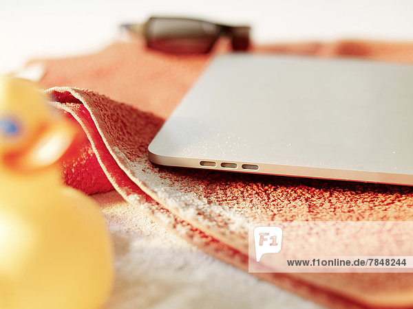 Digitales Tablett auf Strandtuch-Symbol für Sommerferien