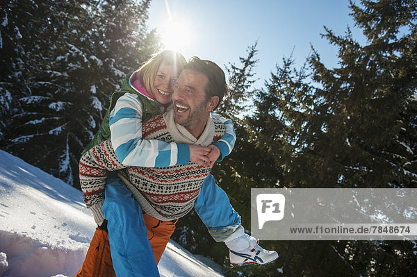 Austria  Salzburg  Man giving piggyback ride to woman  smiling