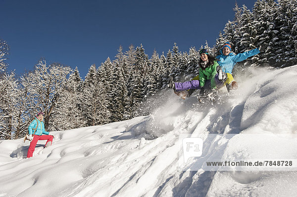 Austria  Salzburg  Young man and women with sledge in snow at Altenmarkt Zauchensee
