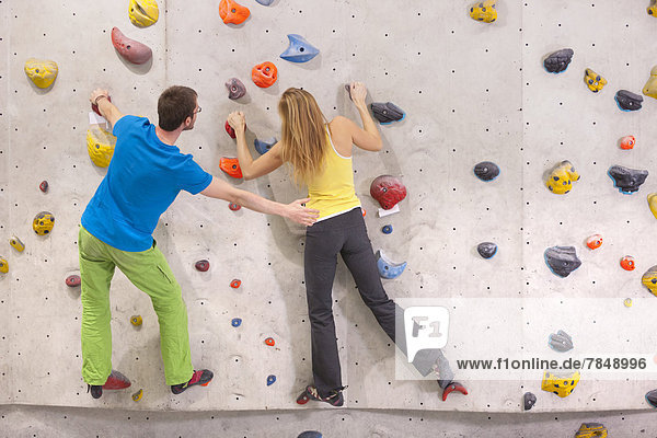Young man helping woman to climb