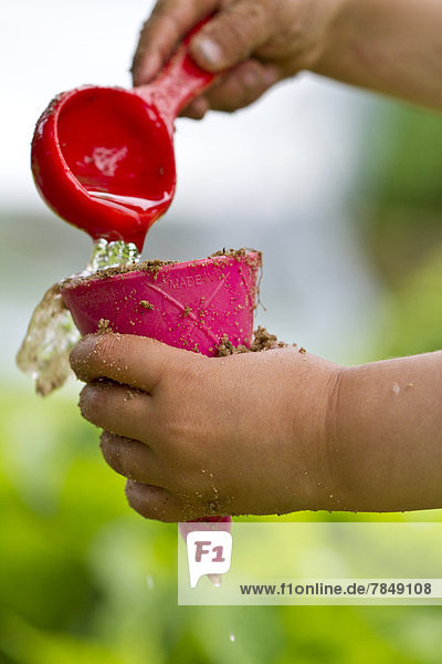 Deutschland  Mädchen spielt mit Wasser  Nahaufnahme