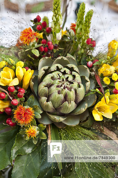 Deutschland  Düsseldorf  Tischdekoration mit Artischocke und Blume  Nahaufnahme