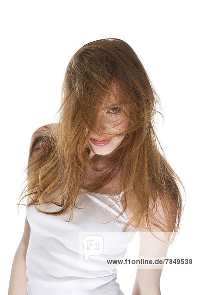 Junge Frau mit windgepeitschten Haaren auf weißem Hintergrund  Nahaufnahme