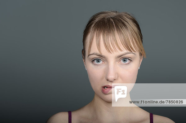 Porträt einer jungen Frau  die die Lippen beißt  Nahaufnahme  Mund