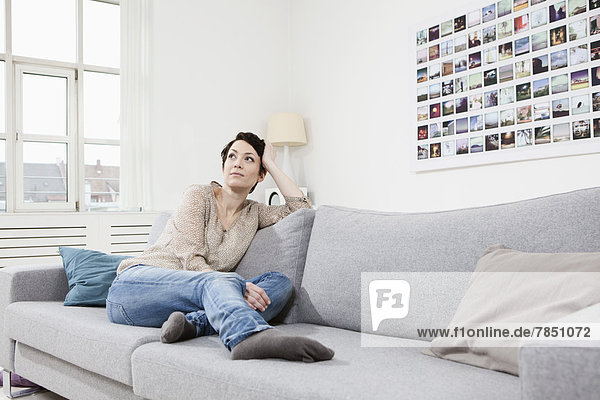 Mid adult woman sitting on couch  looking away