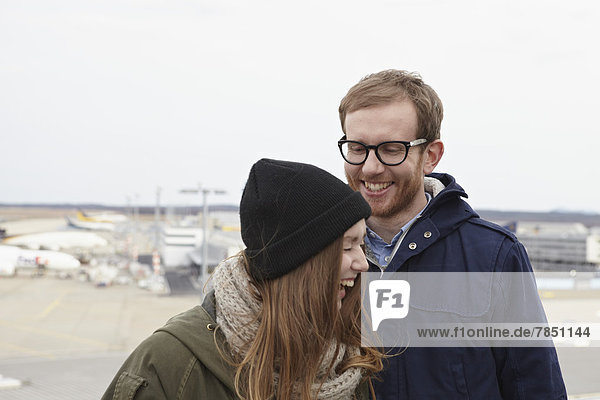 Mid adult man and teenage girl at airport  smiling