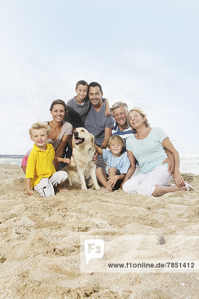 Spain  Portrait of family sitting on beach at Palma de Mallorca  smiling