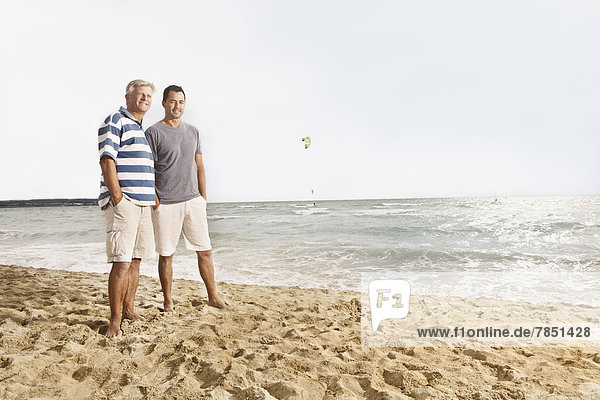 Spain  Men standing on beach at Palma de Mallorca  smiling