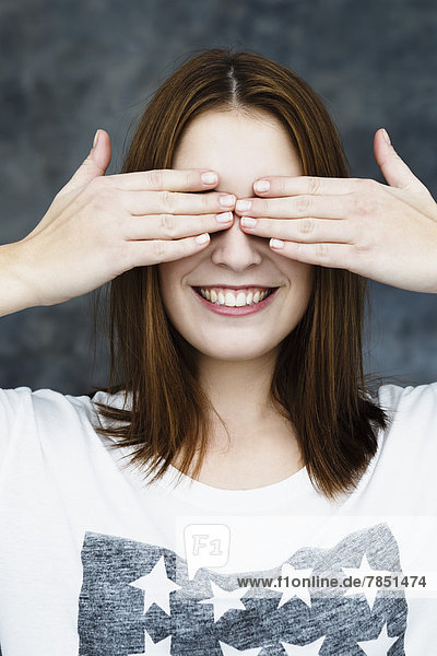 Young woman covering eyes  smiling