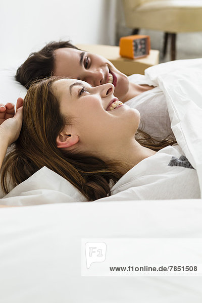 Young couple lying on bed  smiling