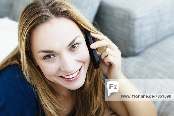 Porträt einer jungen Frau beim Telefonieren  Nahaufnahme