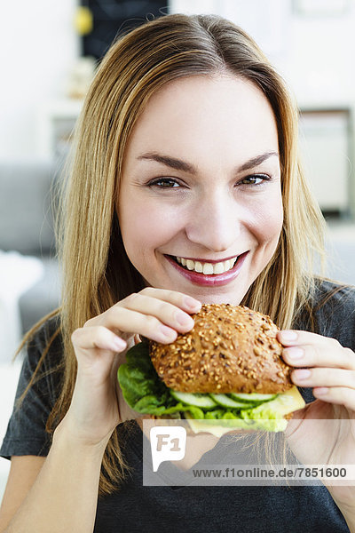 Porträt einer jungen Frau mit Burger  Nahaufnahme