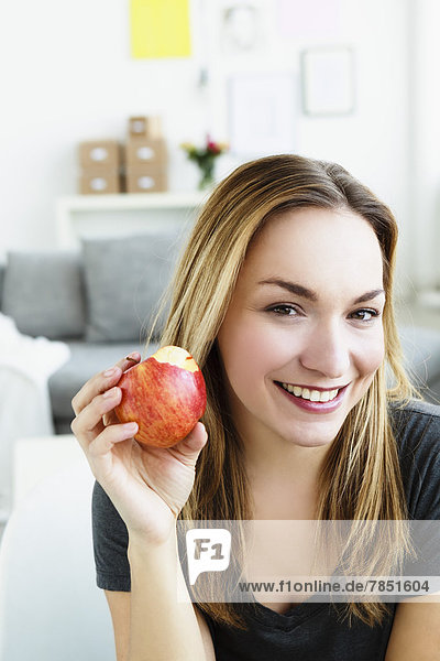 Portrait of young woman holding apple  smiling