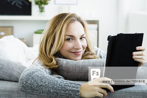 Porträt einer jungen Frau mit digitalem Tablett  lächelnd