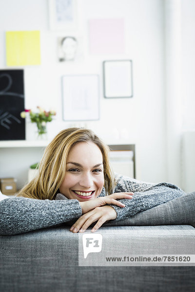 Portrait of young woman relaxing on couch  smiling