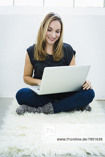 Young woman using laptop  smiling