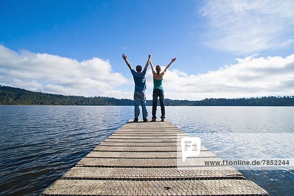 Couple on a jetty at Lake Ianthe  West Coast  South Island  New Zealand  Pacific