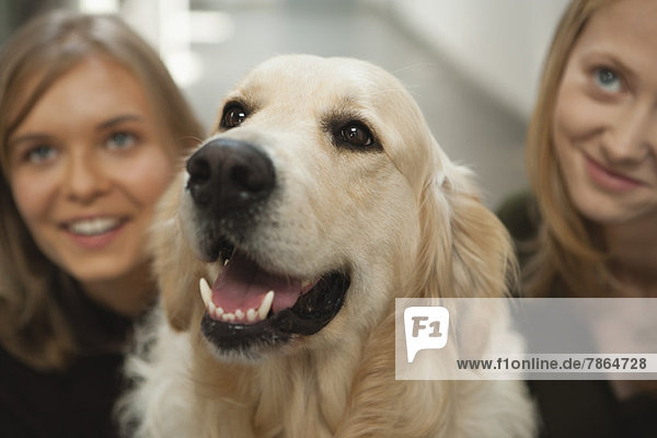 Teen girl and young woman with golden retriever
