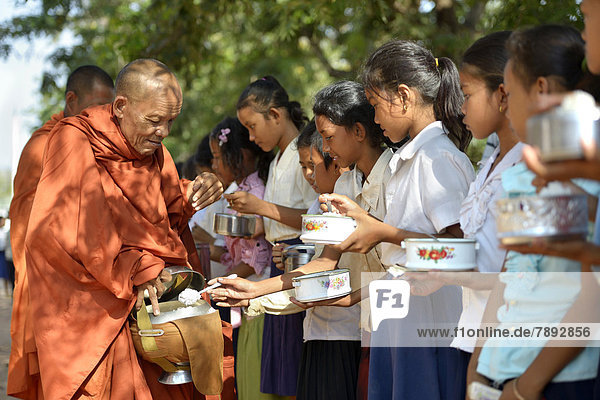 Children donating food and money to a Buddhist monk  traditional ceremony as part of the celebration of the Cambodian New Year