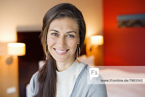 Portrait of a woman smiling in a hotel room