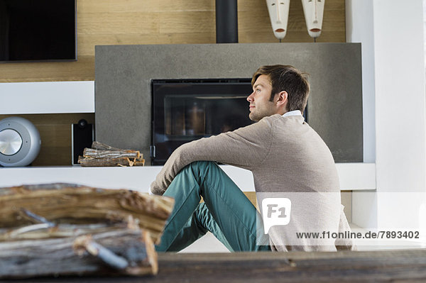 Man sitting in front of a fireplace at home