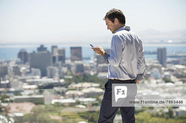 Man standing on the terrace using a mobile phone