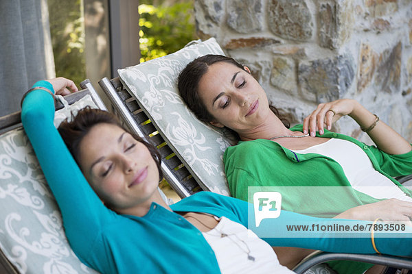 Two women relaxing on lounge chairs