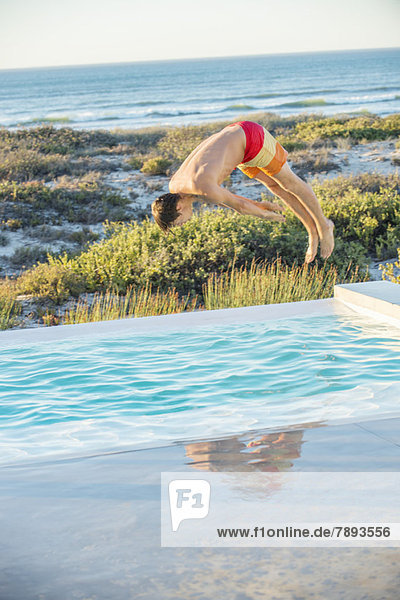 Man diving into a pool near the sea