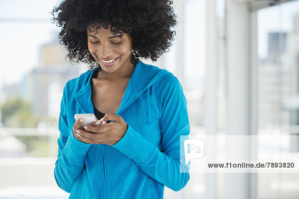 Lächelnde Frau SMS auf dem Handy