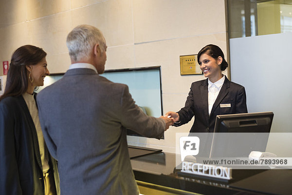 Business couple getting key card at the hotel reception counter