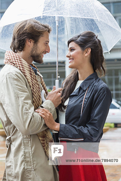 Smiling couple under an umbrella