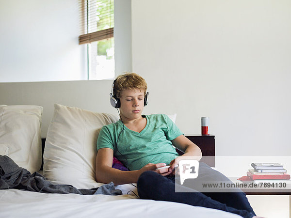Teenage boy listening to music on a mobile phone